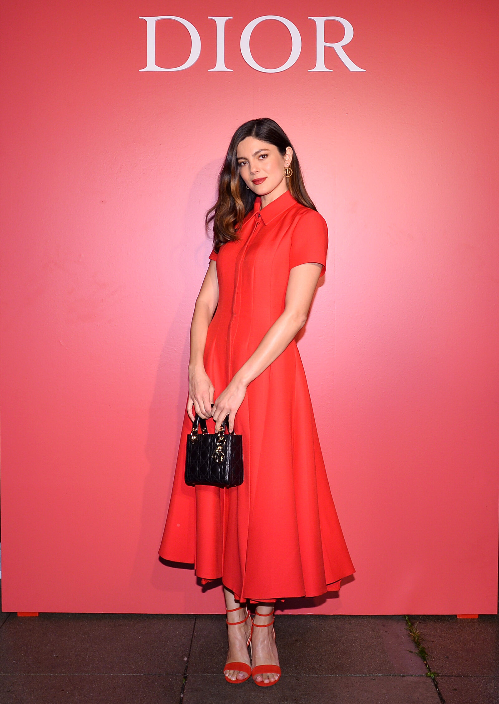 Monica Barbaro embodies Dior's haute couture elegance, her red dress a vibrant punctuation at the Rouge Dior event.