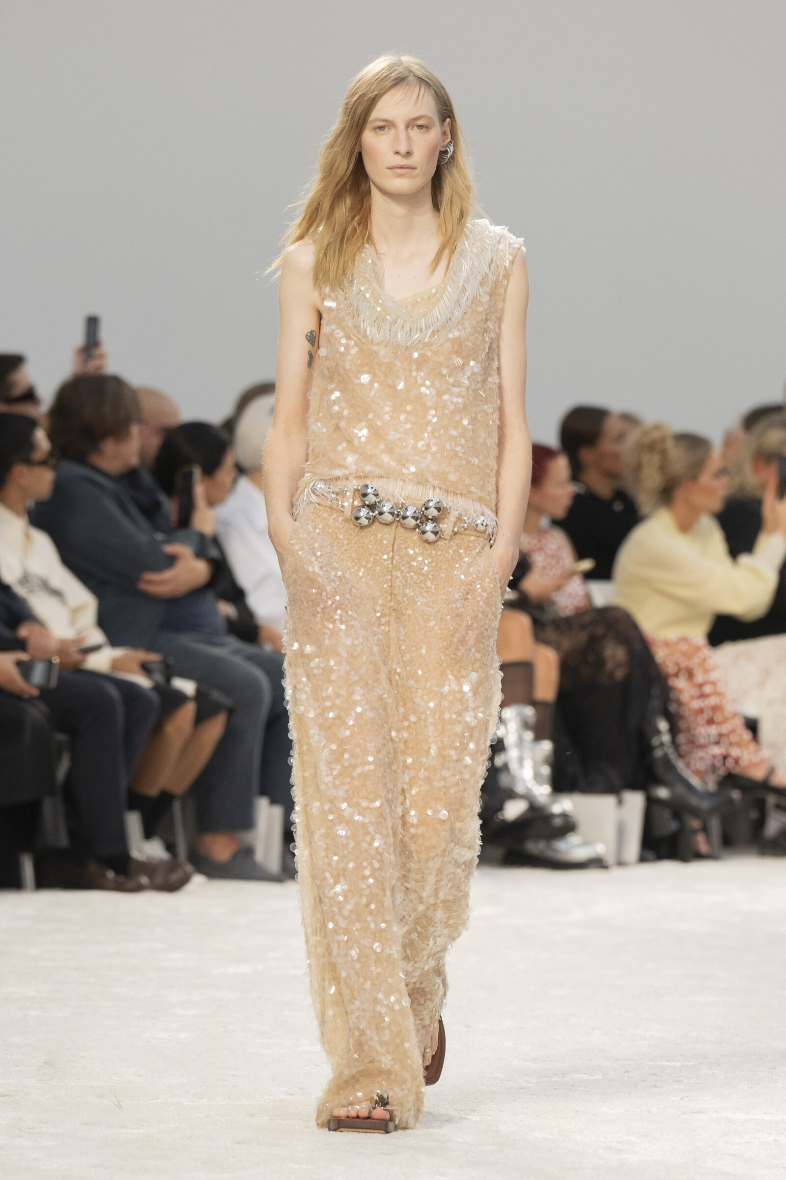 A Rabanne model dazzles in a shimmering SS24 ensemble, modernizing historical femininity.