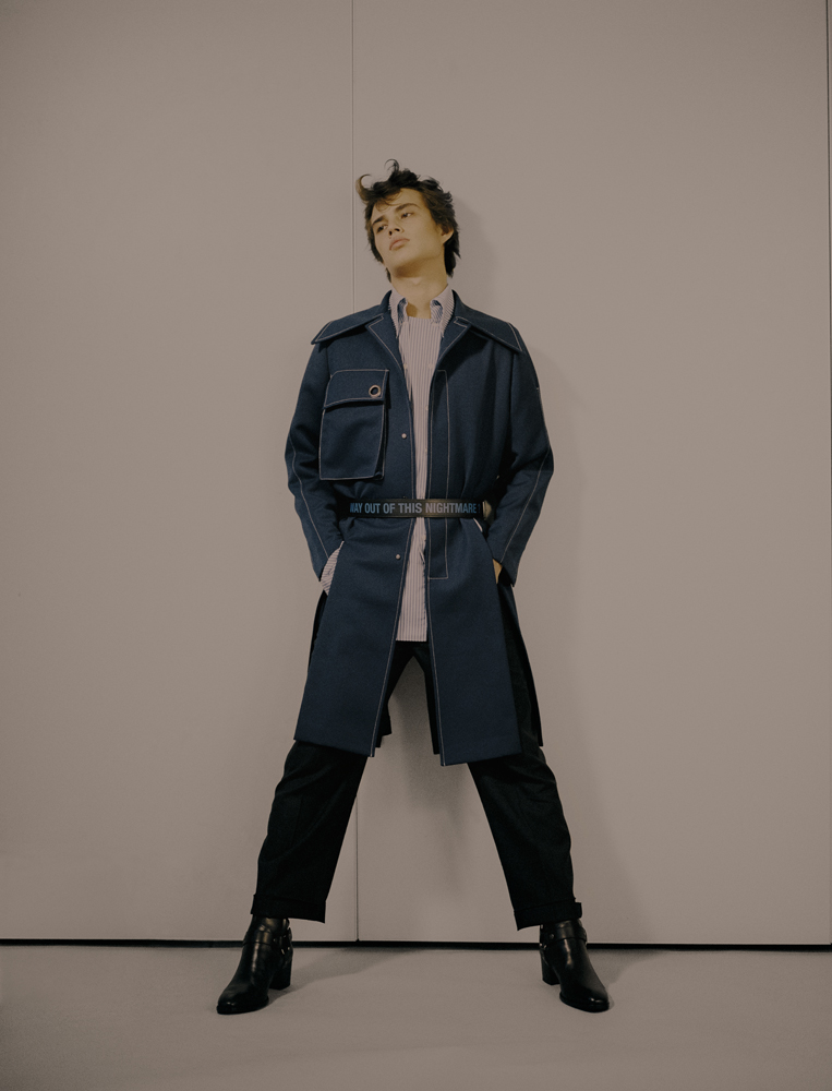 coat by XIMONLEE shirt by DELADA belt by RAF SIMONS, boots by SAINT LAURENT BY ANTHONY VACCARELLO