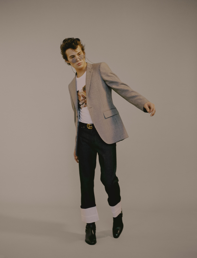 jacket by CALVIN KLEIN 205W39NYC T-shirt by IDEA, pants by LOEWE, sunglasses by THOM BROWNE, belt by GUCCI, boots by SAINT LAURENT BY ANTHONY VACCARELLO