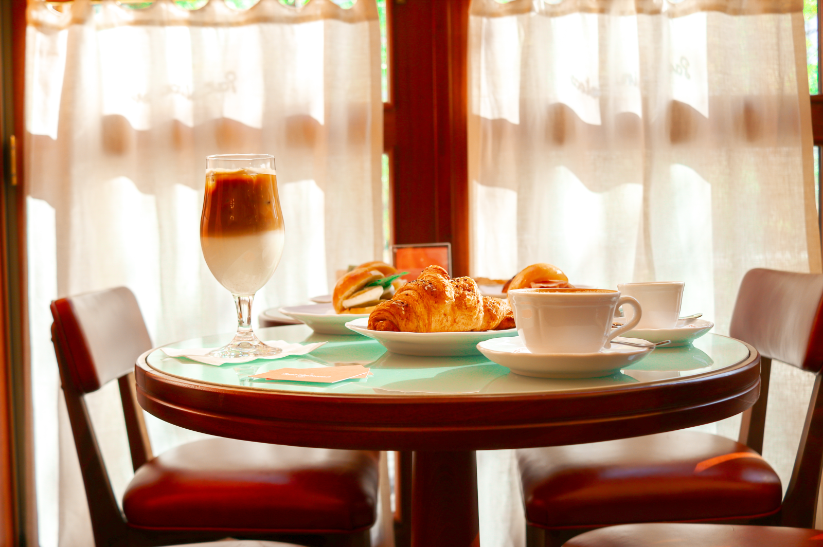 Sant Ambroeus Aspen also welcomes guests with its signature coffee offerings and house-made pastries, perfect for those enjoying the Aspen morning. Morning light streams through Sant Ambroeus Aspen, where signature layered caffè freddo and house-made croissants await guests.