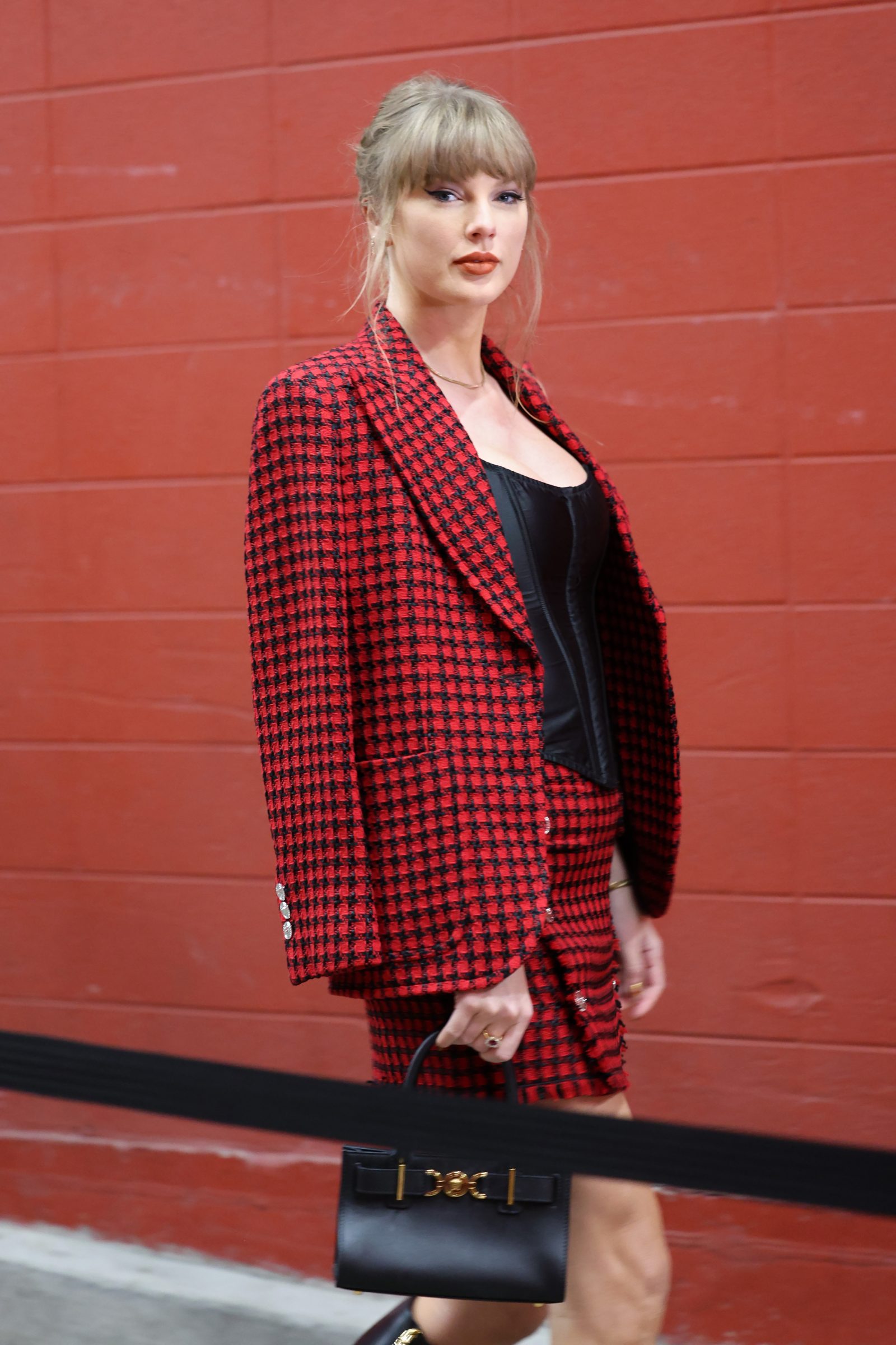 Taylor Swift reinterprets classic tweed with Versace en route to the Kansas City Chiefs vs. Denver Broncos game at GEHA Field at Arrowhead Stadium on November 10, 2024 in Kansas City, Missouri. (Photo by Jamie Squire/Getty Images)