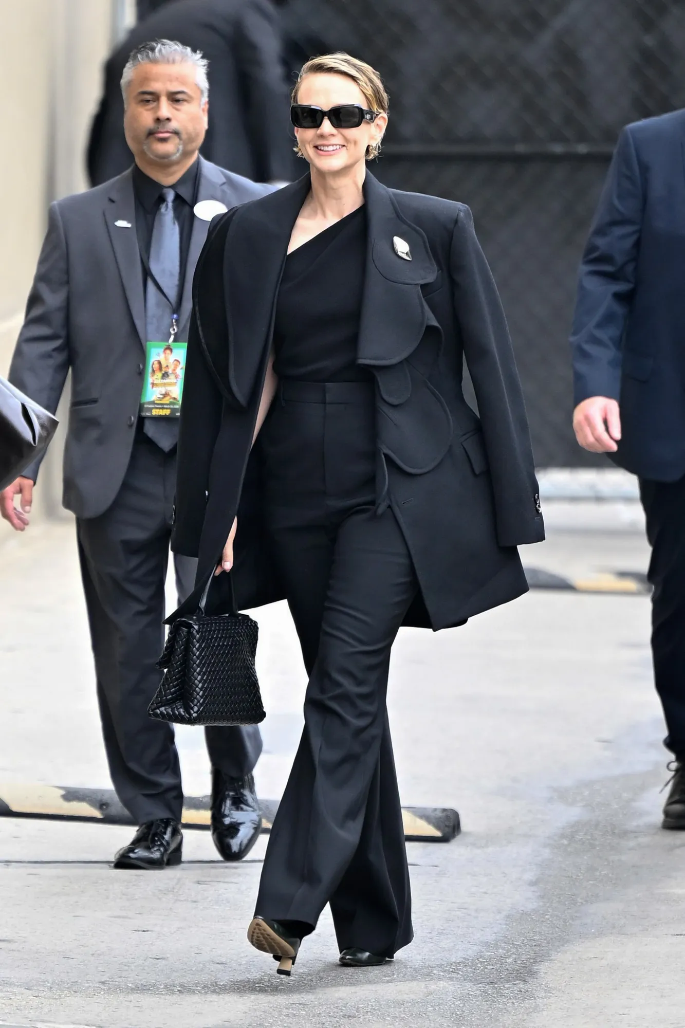 **Photo Caption**: Carey Mulligan is spotted in Los Angeles on March 26, 2025, wearing a Bottega Veneta wool jacket, viscose asymmetric top, flared trousers, Sofia pumps, and the Patti Intrecciato bag. *Photo courtesy of Bottega Veneta.*
